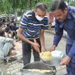 A volunteer distributing free food among deserving people as mercy at a roadside F-7 Markaz