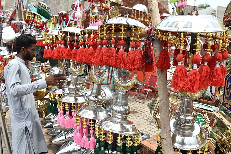 A vendor arranging and displaying the Muharram related stuff during the 08th of Muharram ul Harram