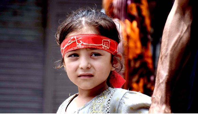 A minor girl attends the 10th Muharram procession to mark Ashoura. Ashoura is the commemoration marking the Shahadat (death) of Hussein(AS), the grandson of the Prophet Muhammad(PBUH), with his family members during the battle of Karbala for the upright of Islam