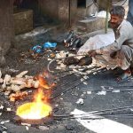Vendor roasting sacrificial animals head and feet at Jhang Bazaar