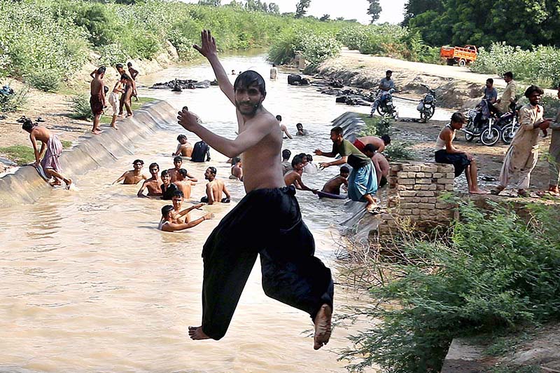 A large number of people enjoy the bathing in the Khisana Mori Canal to get relief from scorching hot weather in the city