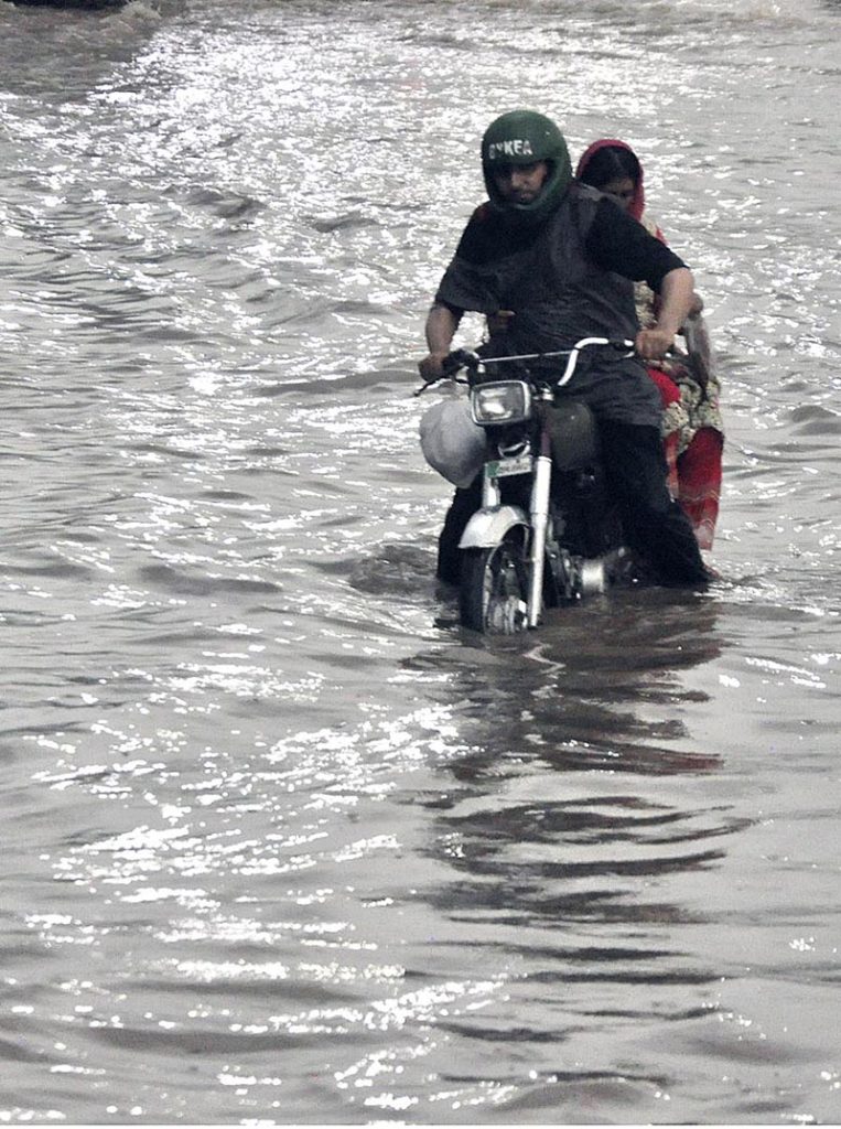 A motorcyclist passing through rain water accumulated on the IJP Road during heavy rain