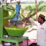 A vendor is busy in preparing a traditional summer drink (Sardai) for customers at his roadside setup