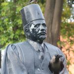 A birds sitting on the statue of Allam Mohammed Iqbal at Alhamra