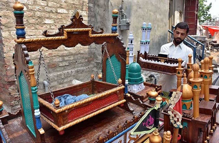 A vendor arranging and displaying the Muharram related stuff during the Holy Month of Muharramul Harram