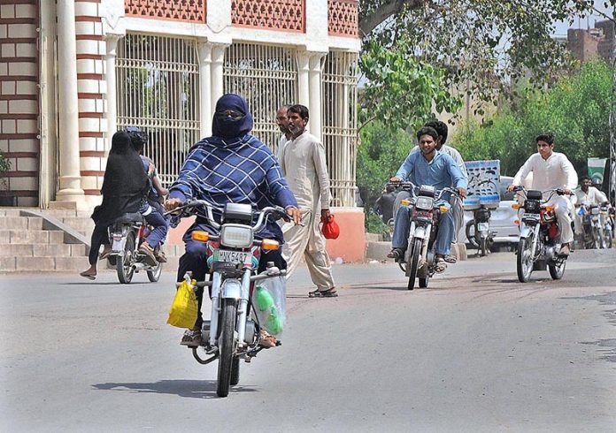 A lady riding a motorcycle heading towards her destination