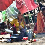 Gypsy woman busy in preparing the food for her family near railway station