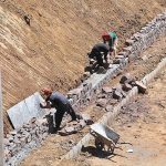Labourers busy construction work of protection wall along Bhara Kahu Bypass