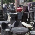 Worker Displaying Flowers pots to attract customers at his workplace
