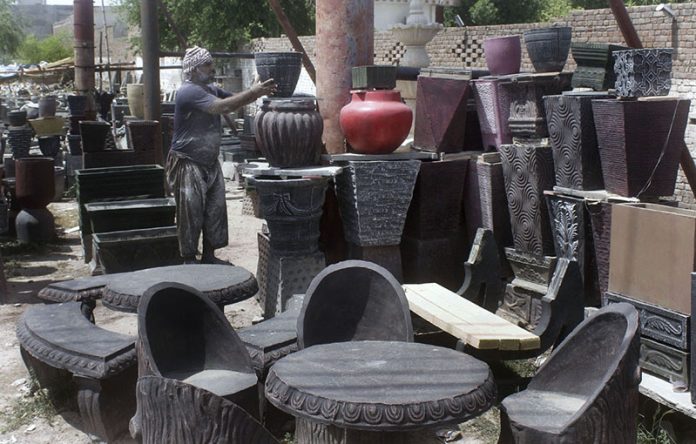 Worker Displaying Flowers pots to attract customers at his workplace