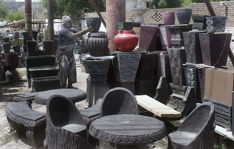 Worker Displaying Flowers pots to attract customers at his workplace