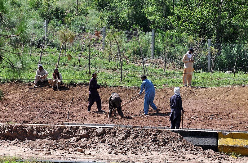 Labourers busy construction work of protection wall along Bhara Kahu Bypass