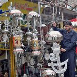 A shopkeeper busy in arranging and displaying Muharram ul Haram related stuff to attract customers during Holy month of Muharram ul Harram.