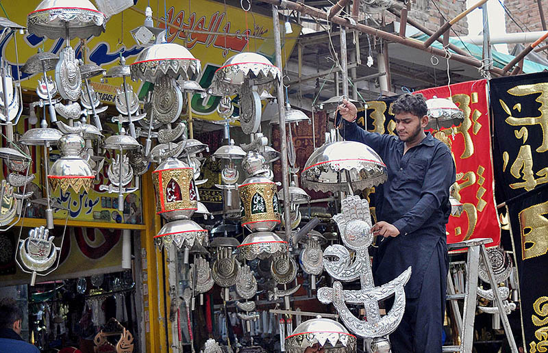 A shopkeeper busy in arranging and displaying Muharram ul Haram related stuff to attract customers during Holy month of Muharram ul Harram.