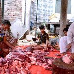 Butchers cutting meat into pieces after slaughtering sacrificial animal on the 3rd day of Eid ul Azha