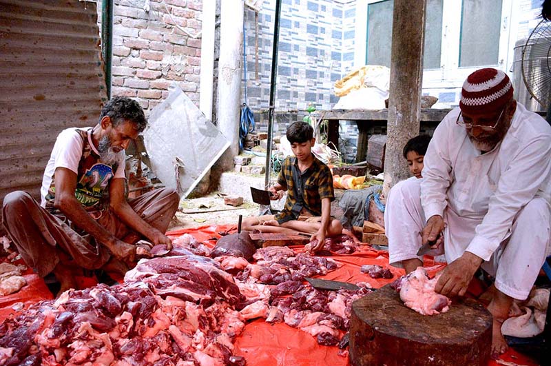 Butchers cutting meat into pieces after slaughtering sacrificial animal on the 3rd day of Eid ul Azha