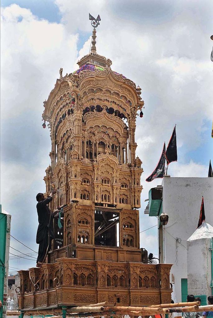 A worker busy in spraying color on the historical Tazia of Ustad for the preparation in connection with Youm-e-Ashor at Pak Gate