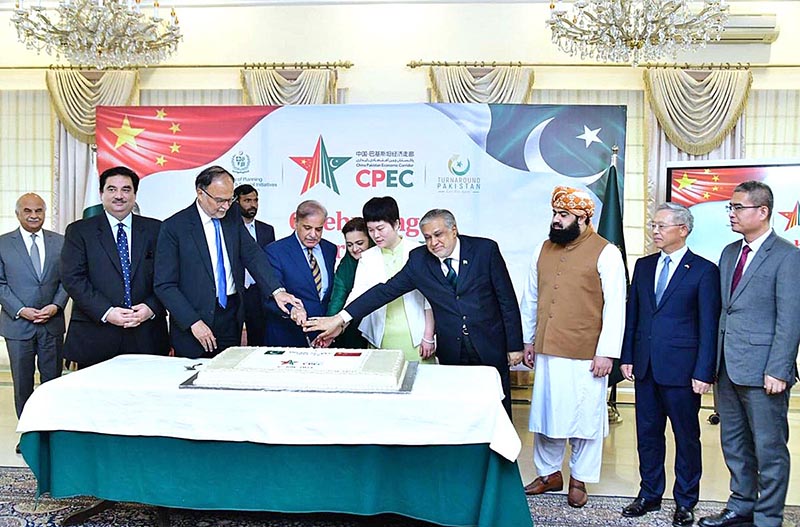 Prime Minister Muhammad Shehbaz Sharif, Chargé d'affaires of the Chinese Embassy in Islamabad Ms. Pang Chunxue and Federal Ministers cutting a cake marking the 10th anniversary of the signing of the agreement for CPEC