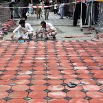 Labourers busy in fixing tiles on footpath at Aabpara Market.