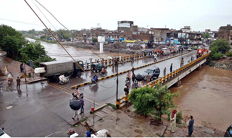 Vehicles passing through rain water accumulated on road during torrential rain since last night
