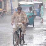 A cyclist on the way during monsoon rain in the city