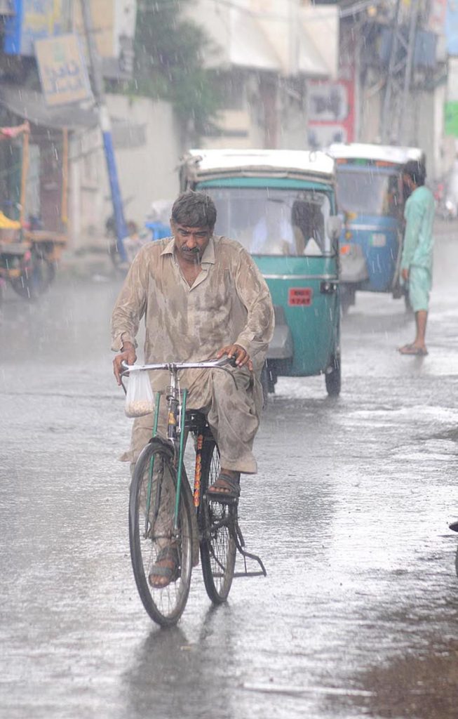 A cyclist on the way during monsoon rain in the city