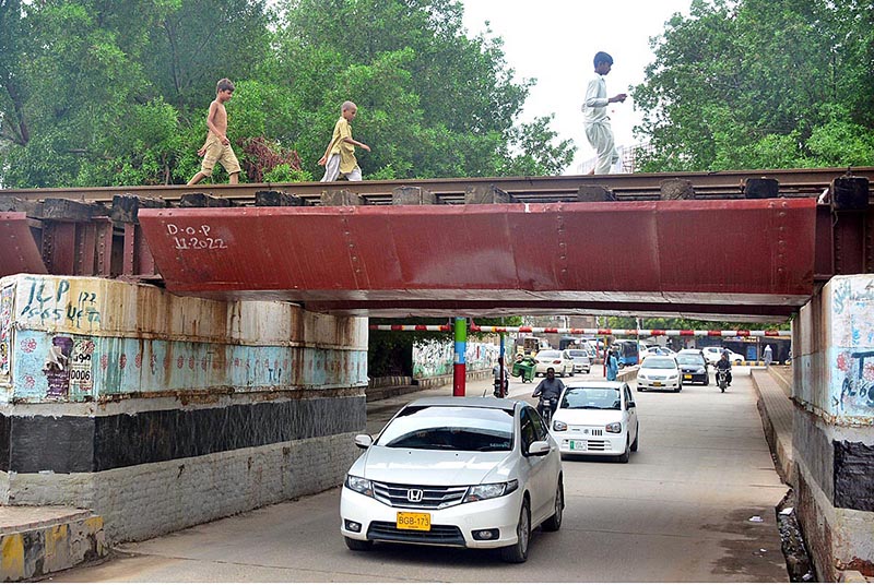 Children passing through rail bridge at Latifabad