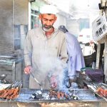 A vendor busy in preparing traditional Seekh Kabaab on 3rd day of Eidul Adha at his road side setup to attract customers