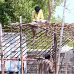 Gypsy men making a makeshift home along the roadside.