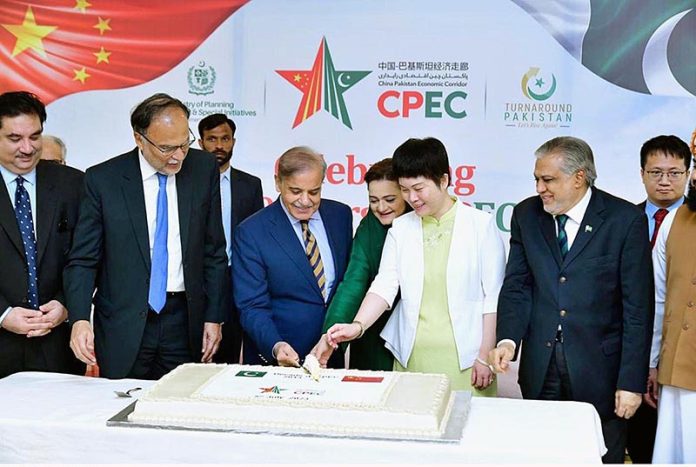 Prime Minister Muhammad Shehbaz Sharif, Chargé d'affaires of the Chinese Embassy in Islamabad Ms. Pang Chunxue and Federal Ministers cutting a cake marking the 10th anniversary of the signing of the agreement for CPEC