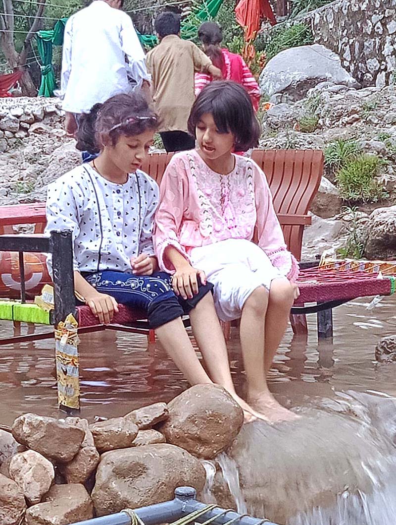 Young girls enjoying in the water at Shahdara valley near outskirts of the Federal Capital