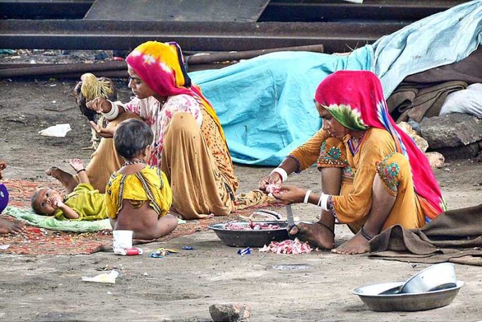 Gypsy woman is cocking for her family under the flyover at Latifabad