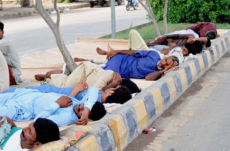 Labourers taking nap on footpath during a hot day in the city