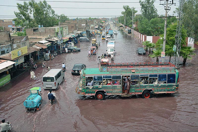 Vehicle drivers facing difficulties while passing through stagnant rain water accumulated at Nishatabad after heavy rain in the city