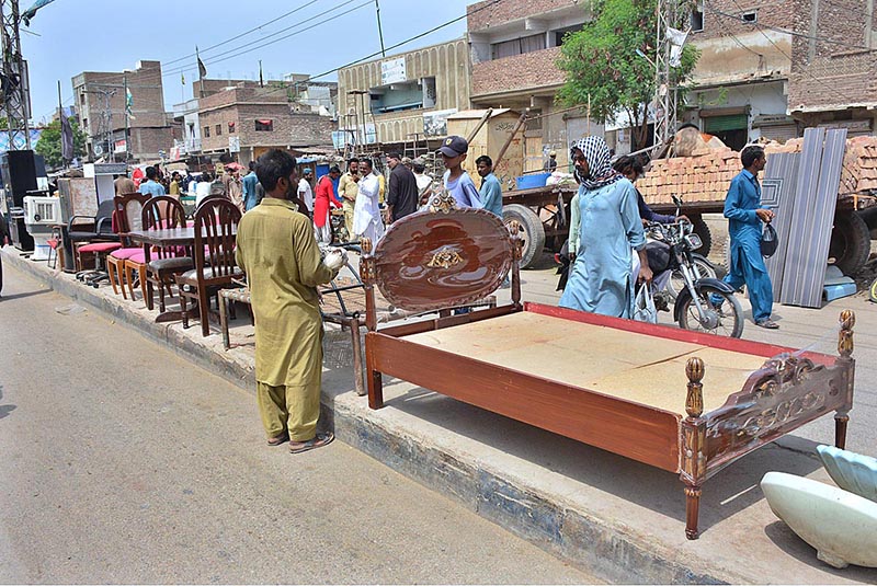 Mechanic busy in repairing sewing machine of woman customer at his roadside setup