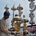 A shopkeeper displaying Muharram-ul-Harram related stuff to attract the customer at City Road Imam Bargah.
