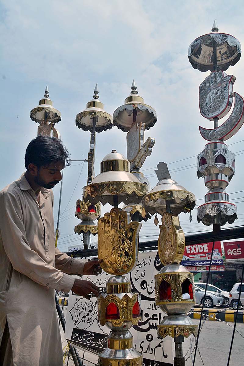 A shopkeeper displaying Muharram-ul-Harram related stuff to attract the customer at City Road Imam Bargah.