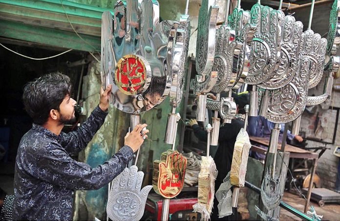 A vendor displaying the Muhrram related stuff to attract the customer at Qadamgah Mola Ali