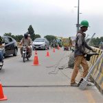 Labourer busy installing iron bars on the roadside divider of Kalma Chowk Flyover to protect from any mishap