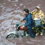 A motorcyclist passing through rain water accumulated at Nishatabad after heavy rain in the city