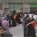 People standing in a queue waiting their turn outside Utility Store to purchase grocery items at subsidized rates at Chungi no.07