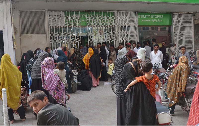 People standing in a queue waiting their turn outside Utility Store to purchase grocery items at subsidized rates at Chungi no.07