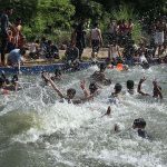 A large number of youngsters enjoy bathing in the local swimming pool at Khisana Mori to get relief from scorching hot weather in the city