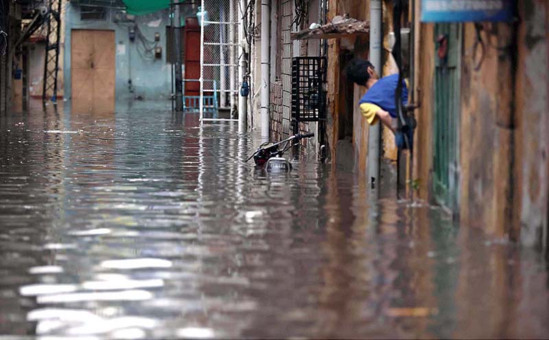 Vehicles passing through rain water accumulated on road during torrential rain since last night
