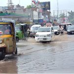 Vehicles are passing through the stagnant water at Sargodha Road during heavy rain