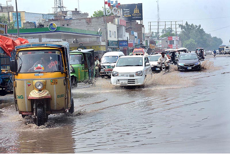 Vehicles are passing through the stagnant water at Sargodha Road during heavy rain
