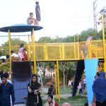 Children enjoying swings with their family members in Bagh e Jinnah