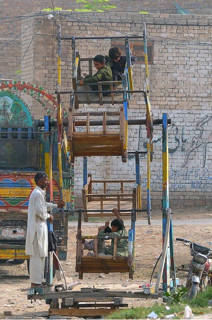Children enjoying a portable swing at roadside