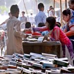 Book lovers selecting old books on a roadside stall in the city