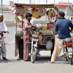 Customers purchasing traditional handmade items from roadside vendor